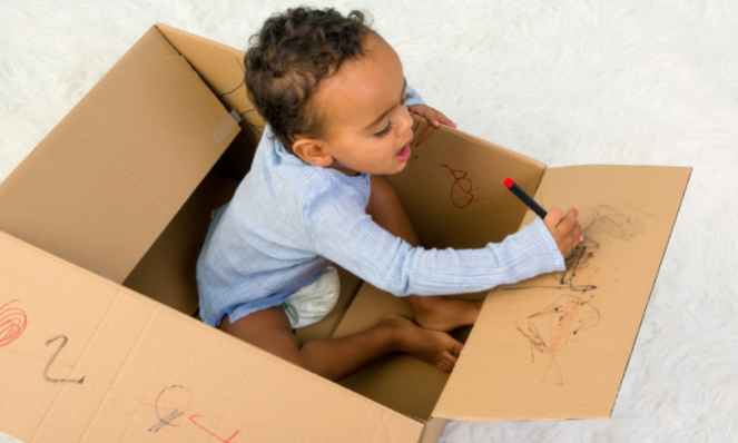 kid playing in a cardboard box. free alternative to the nugget comfort couch