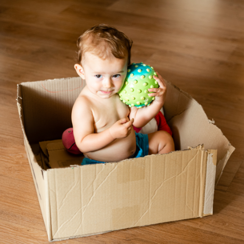 baby playing in a cardboard box