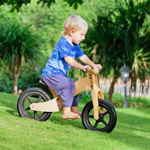 kid riding a wooden balance bike