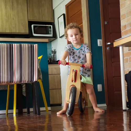 kid riding a wooden balance bike
