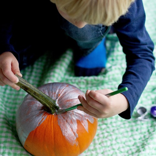boy painting a pumpkin