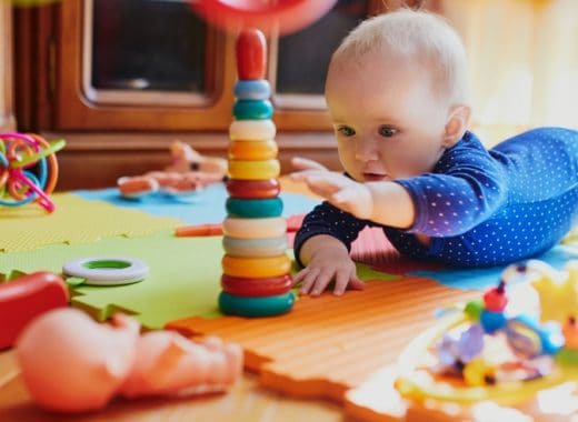 A baby reaches for a crawling baby toy.