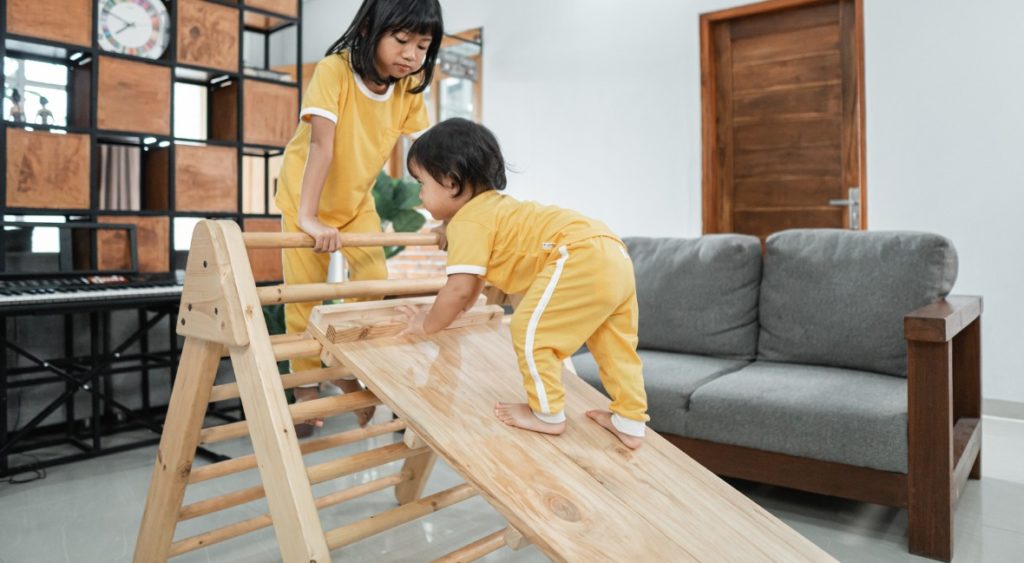 kids climbing a foldable pikler triangle