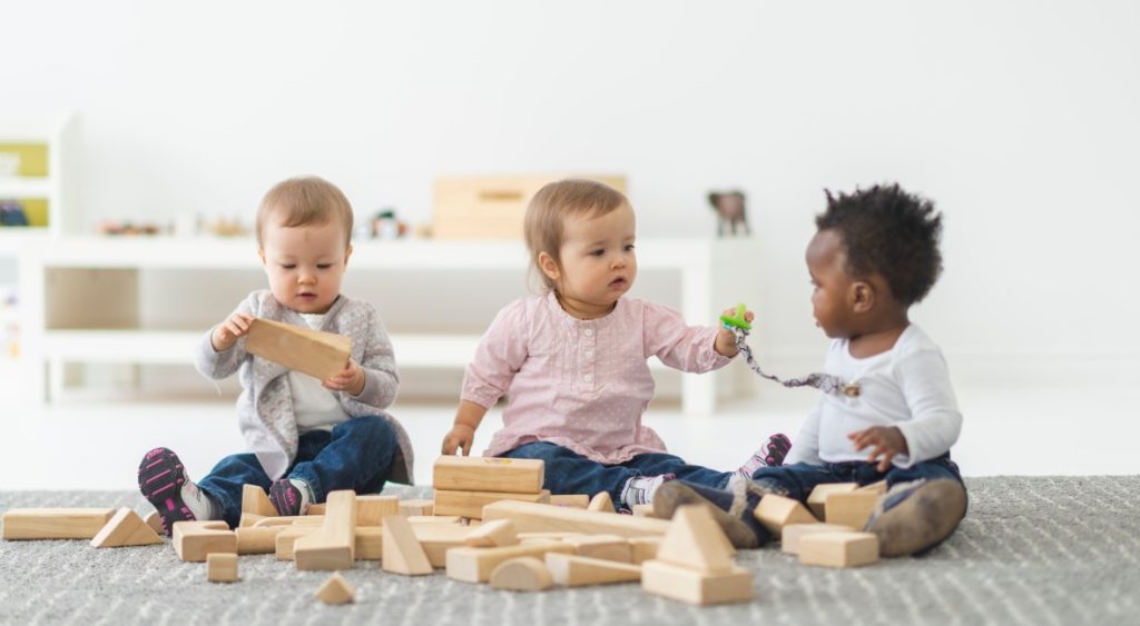 babies playing with wooden blocks