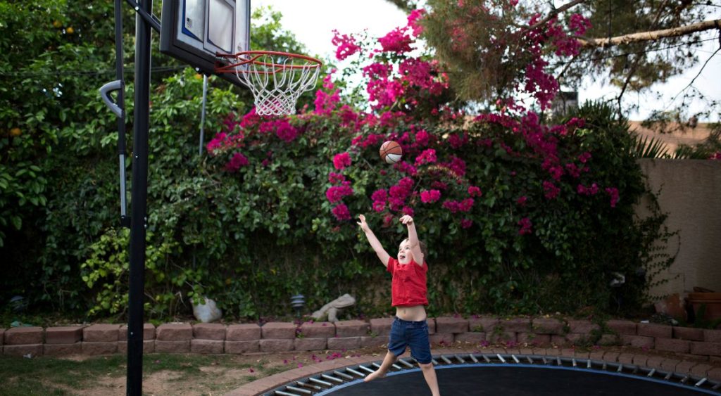 kid playing trampoline basketball