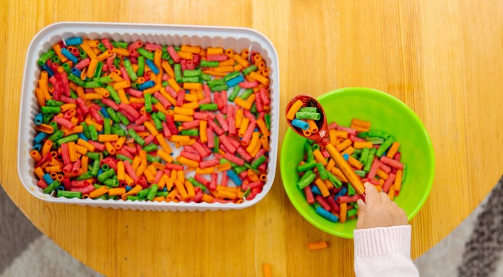 dyed pasta in a sensory bin