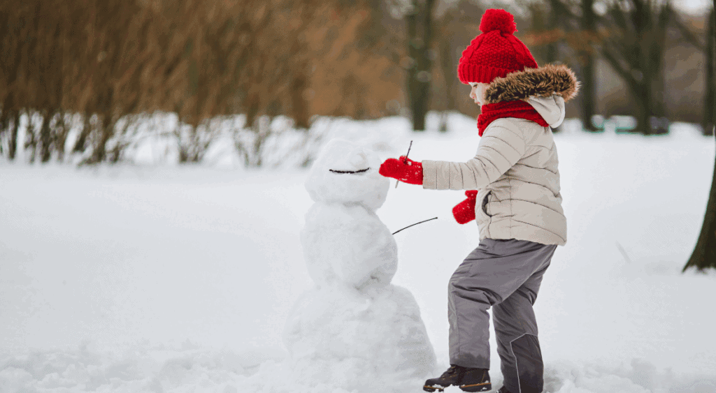 A kid builds a snowman for Christmas